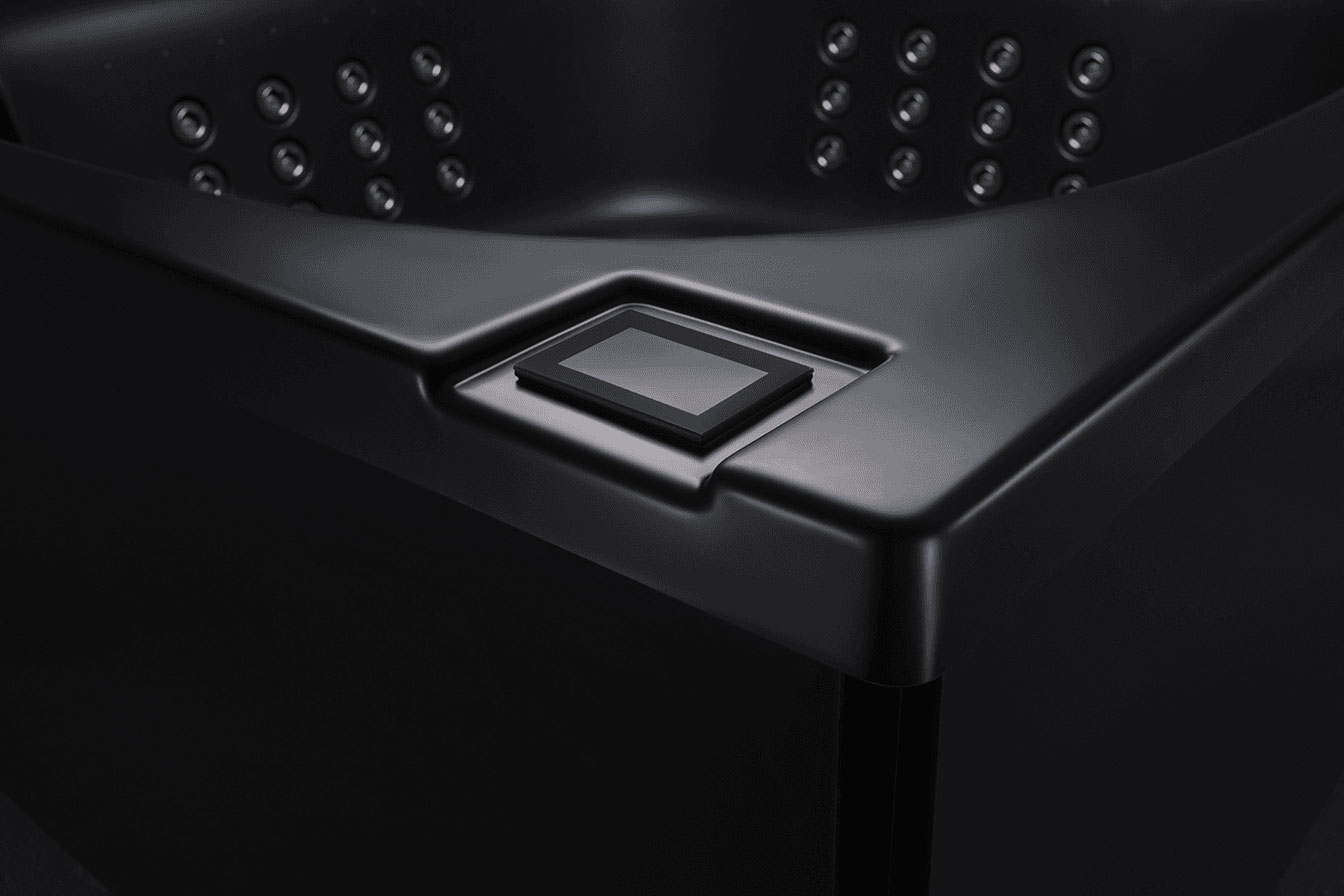 Black modern jacuzzi close up, showing water jets and built-in control panel
